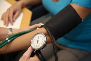 Arzt mit Stehtoskop misst Patient den Blutdruck