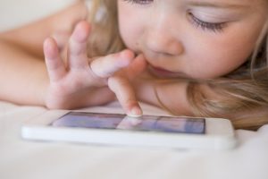 Pretty kid playing game smartphone indoor