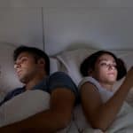 Onlinesein oder Nichtsein? Plädoyer für vermehrte Offline-Existenz Young couple with smartphones in their bed