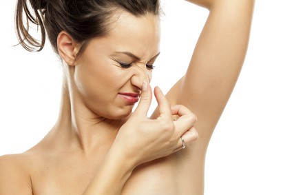 A young woman is disgusted by the scents of her armpits